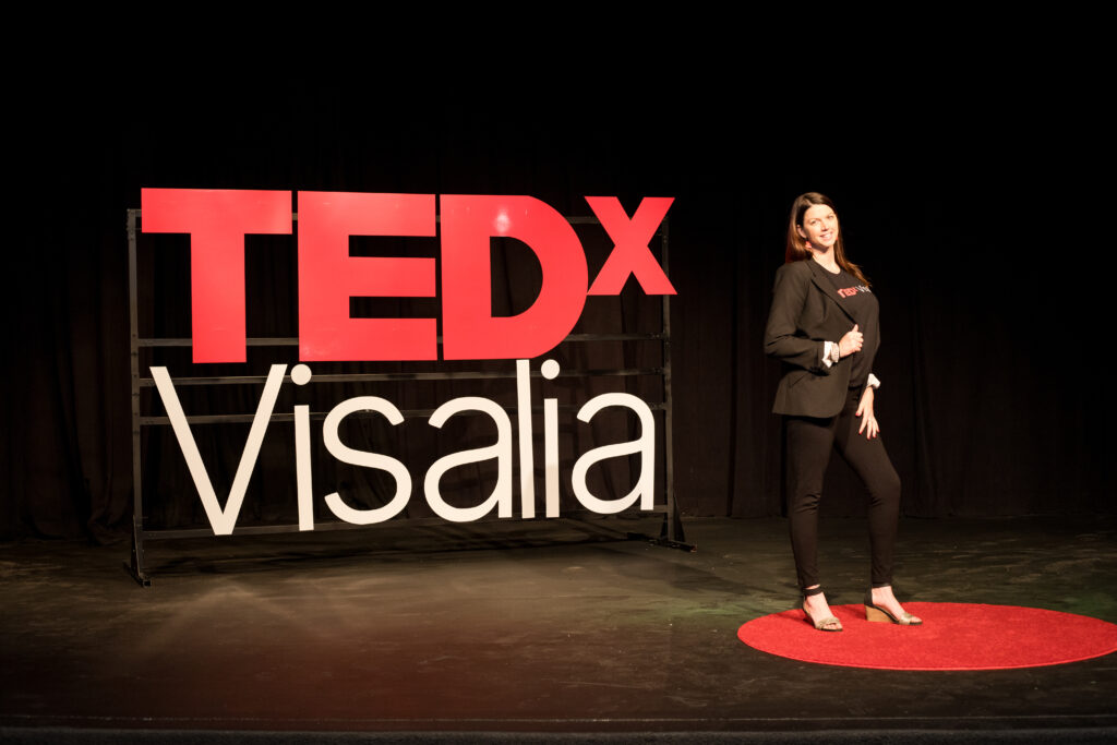 A woman standing on the stage at tedx